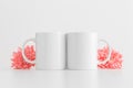 Two mugs mockup with pink chrysanthemums on a white table