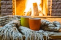 Two mugs for tea or coffee before fireplace. Royalty Free Stock Photo