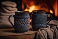 Two mugs for tea or coffee, woolen things near cozy fireplace winter vacation Royalty Free Stock Photo