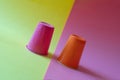 Two multi-colored plastic cups tilted on a yellow and pink background. Concept of business volatility and falling investment