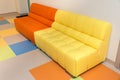 Two multicolored yellow and orange sofas on a color floor Royalty Free Stock Photo