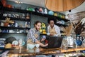 Two multicultural people working on laptop during inventory