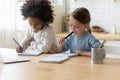 Two multi ethnic sisters little girls doing homework at home Royalty Free Stock Photo