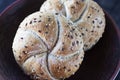 Two multigrain buns with sesame seeds and flaxseed on a brown plate. Royalty Free Stock Photo