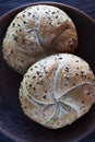 Two multigrain buns with sesame seeds and flaxseed on a brown plate. Royalty Free Stock Photo