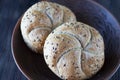 Two multigrain buns with sesame seeds and flaxseed on a brown plate Royalty Free Stock Photo