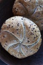 Two multigrain buns with sesame seeds and flaxseed on a brown plate Royalty Free Stock Photo