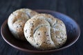 Two multigrain buns with sesame seeds and flaxseed on a brown plate. Royalty Free Stock Photo