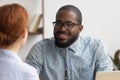 Two multiracial business partners speaking, discussing, sharing ideas