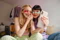 Two multiracial girls in eye patches taking selfie on mobile phone Royalty Free Stock Photo