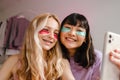 Two multiracial girls in eye patches taking selfie on mobile phone Royalty Free Stock Photo