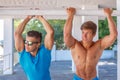 Two muscular guys posing with hands up. Royalty Free Stock Photo