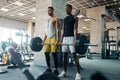 Two muscular men poses with heavy barbell in gym Royalty Free Stock Photo