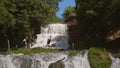 Two musicians Pianist and bandurist playing on the rocks at waterfall