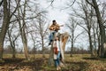 Two musicians playing music in a beautiful leafless autumn forrest