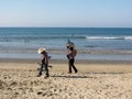 Two musicians stroll on beach carrying their instruments. Royalty Free Stock Photo