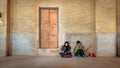 Two Muslim female students dressed in Islamic hijab are doing homework sitting inside an old building