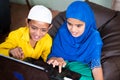 Two muslim teenager kids excited over using laptop at home - concept of kids using modern technology and internet Royalty Free Stock Photo