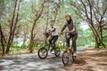 Two Muslim women cycling on a road with trees Royalty Free Stock Photo