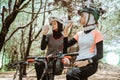 Two Muslim women drinking mineral water bottles during cycling break Royalty Free Stock Photo