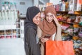 Two Muslim women using a smartphone and carrying a bag Royalty Free Stock Photo