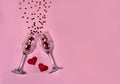 Two narrow empty glasses , red hearts and stars on a pink background. Free space for your text. Royalty Free Stock Photo