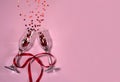 Two narrow empty wine glasses tied with a red ribbon, and stars on a pink background. Royalty Free Stock Photo