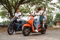 Two naughty high school girls riding motorbikes teasing boy students Royalty Free Stock Photo