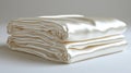 Two neatly folded stacks of luxurious, creamy-white satin fabric sheets Royalty Free Stock Photo