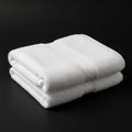 Two neatly folded white towels are placed on a smooth black surface Royalty Free Stock Photo