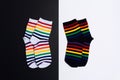 Two negative white and black background with two pair of socks with colorful striped pattern
