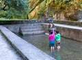 Two nepalese girls buddhist ceremony pray inside holy waterpool.