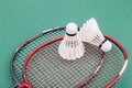 Two new badminton shuttlecock with rackets on green mat court Royalty Free Stock Photo