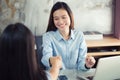 Two new generation business women shaking hands