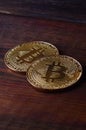 Two new golden physical bitcoins lies on dark wooden backgound, close up. High resolution photo. Cryptocurrency mining concep