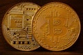 Two new golden physical bitcoins lies on dark wooden backgound, close up. High resolution photo. Cryptocurrency mining concep