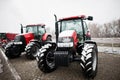 Two new red tractor stay at snowy weather background combaine