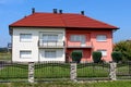 Two new attached suburban family houses with wrought iron fence surrounded with grass and decorative vegetation Royalty Free Stock Photo