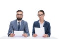 two newscasters with papers sitting at table and looking at camera, Royalty Free Stock Photo