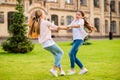 Two nice attractive lovely cheerful cheery pre-teen girls wearing casual having fun traveling abroad spinning holding Royalty Free Stock Photo