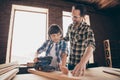 Two nice focused inspired cheerful creative person master builder dad teaching son explaining training fixing repairing