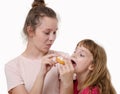 Two nice girls eat delicious sweet donut and smile Royalty Free Stock Photo