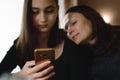 Two nice girls are sitting in a cafe and using mobile phones Royalty Free Stock Photo