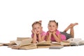 Two nice little girl lying on pile of books