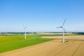 Two Norman wind turbines in the middle of flax and wheat fields in Europe, France, Normandy, in summer on a sunny day Royalty Free Stock Photo