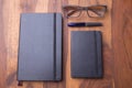 Two notebook on a wooden table with wooden glasses and a pen Royalty Free Stock Photo