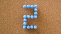Two, number made by pastel blue pushpin on cork board texture Royalty Free Stock Photo