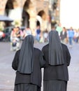 Two nuns with long dresses and a veil to cover the hair they wal