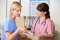 Two Nurses Discussing Patient Notes At Nurses Station Royalty Free Stock Photo
