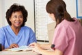 Two Nurses In Discussion At Nurses Station Royalty Free Stock Photo
